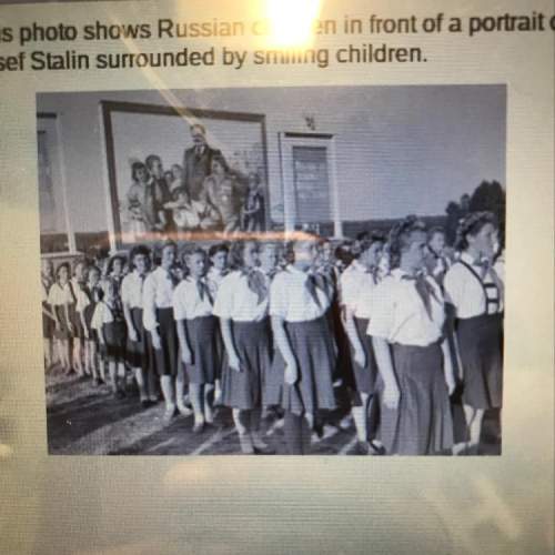 This photo shows russian children in front of a portrait of which characteristic of totalitarianism