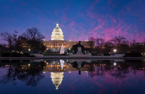 On a beautiful night in washington d.c., you see a mirror image of us capitol and surrounding scener